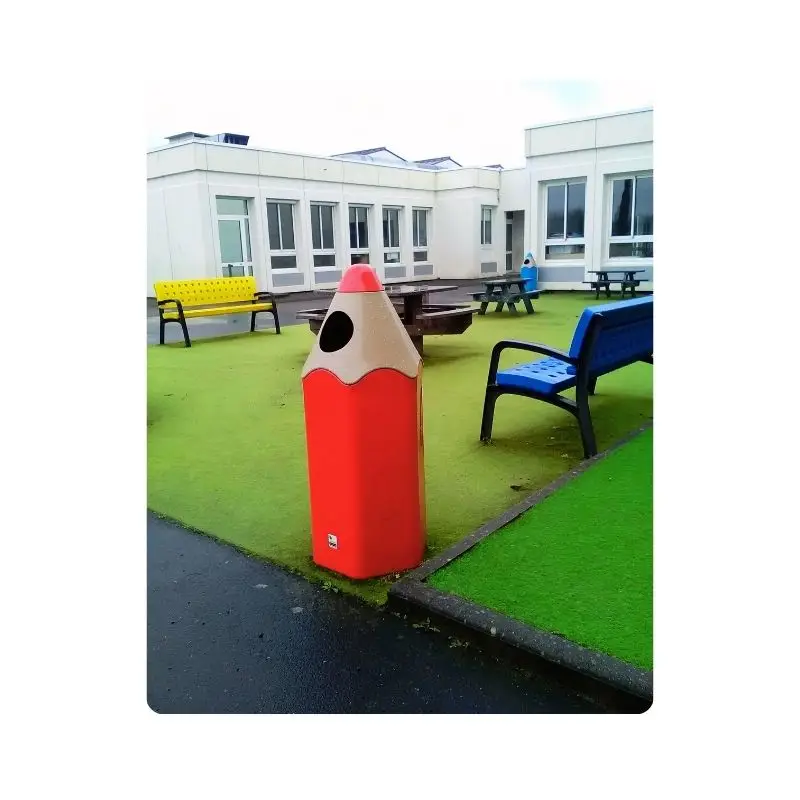 Poubelle en forme de crayon rouge dans cour d'école