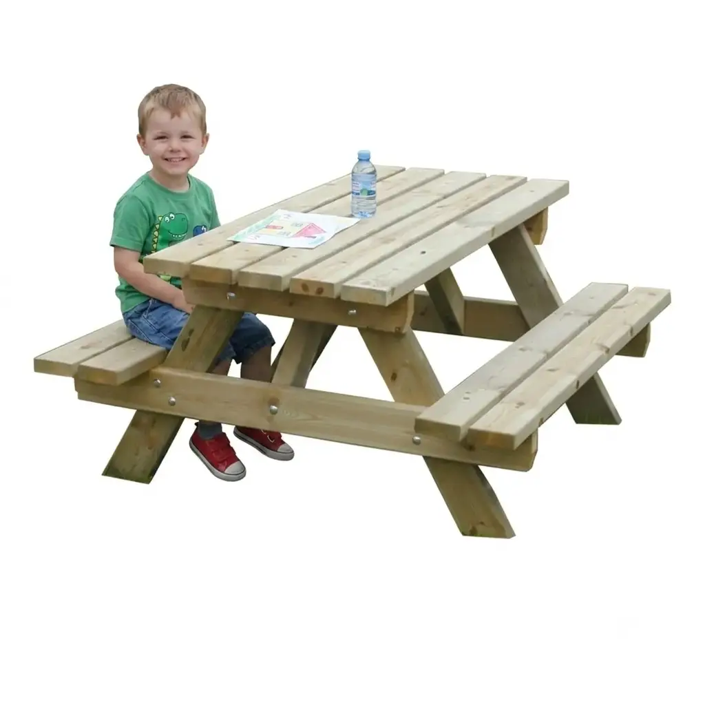 Enfant souriant assis sur une table de pique-nique en bois